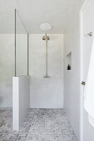 Modern bathroom with open shower, partition wall and grey floor tiles