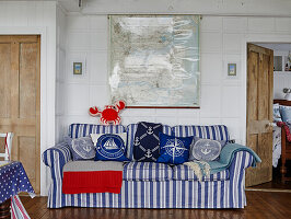 Striped sofa with nautical cushions in front of a map in the living room