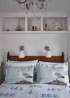 Maritime-inspired bedroom with seagull bed linen and ship models