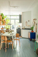 Open-plan living room with dining area and kitchen with green wooden floor