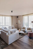 Modern living room with light-coloured upholstered furniture and wooden flooring