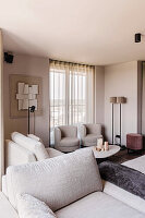 Bright living room with beige upholstered furniture and modern mural