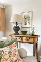 Rustic side table with table lamp, ceramic bowl and fern in glass