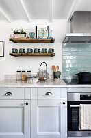 Country-style kitchen with open wooden shelves and light blue tiles