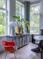 Modern living room with striped sideboard, indoor plants and floor lamp