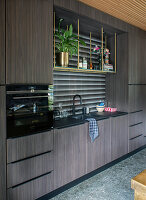 Fitted kitchen with dark wood elements and golden accents