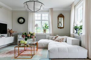 Bright living room with white corner sofa and copper-look coffee tables