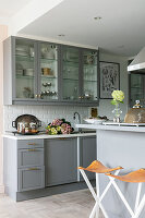 Modern grey kitchen with glass fronts and kitchen island