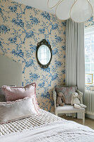 Bedroom with blue floral wallpaper and antique mirror