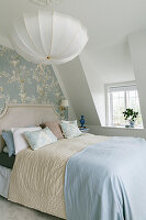 Bedroom with blue chinoiserie-style wallpaper and white lampshade