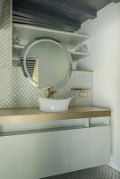 Bathroom with round mirror, modern washbasin and fish scale tiles