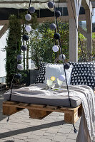 Hanging pallet bench with cushions and drinks on terrace