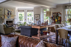 Open-plan living room with rustic wooden furniture and paintings on the wall