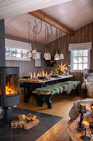 Rustic dining area with wood panelling, open fire and Christmas decorations