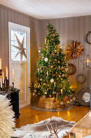 Weihnachtlich geschmückter Wohnraum mit Tannenbaum und Kerzenleuchtern