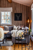 Gemütliche Sitzecke mit Fellakzenten im Wohnzimmer mit Holzwänden