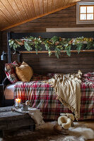 Hochbett mit schmückender Tannengirlande in rustikalem Holzraum