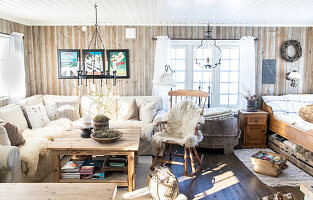 Bright living room with wood panelling, rustic furnishings and cosy upholstered furniture