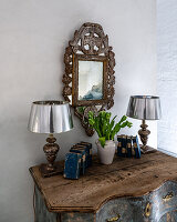 Antiker Spiegel über rustikaler Kommode mit Tulpenarrangement