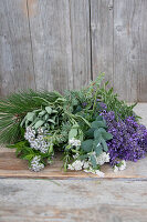 Herb bouquet of pine, lavender, sage and yarrow on a wooden table