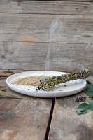 Burning bundle of incense on a ceramic plate