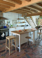 Country-style kitchen with exposed wooden beams and terracotta tiled floor
