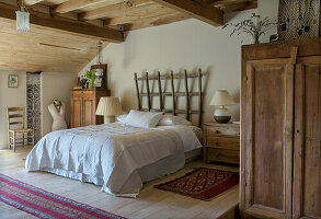 Rustic bedroom with wooden beamed ceiling and carpets
