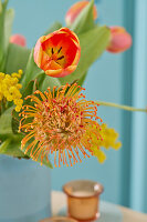 Colourful spring bouquet with tulips (Tulipa) and pincushion (Leucospermum) in vase