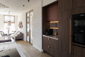 Modern kitchen with dark brown wooden fronts and integrated dining area