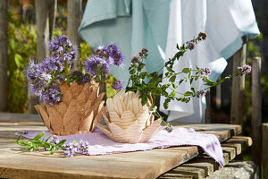 Holz- und Korkvasen in Artischocken-Form auf Holztisch im Freien