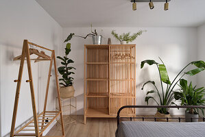 Minimalist bedroom with open wardrobe and indoor plants