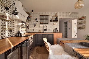 Kitchen with patterned tiles, dining table and wooden worktop