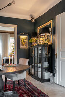 Esszimmer mit dunkler Vitrine und hellem Holzboden