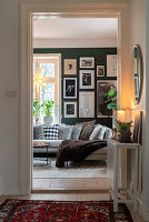 Blick ins Wohnzimmer mit grün gestrichener Bilderwand