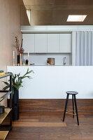 Minimalist kitchen with white counter and dark wooden floor