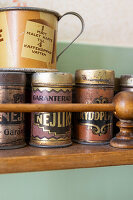 Metal storage tins on a wooden kitchen shelf