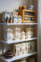 Storage tins and retro radio on a vintage-style kitchen shelf