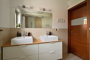 Bathroom with double washbasin and wooden door