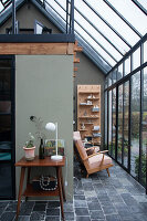 Wintergarten mit Vintage-Möbeln und Holzregal mit Dekoelementen