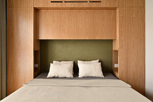 Wood-panelled bedroom with integrated storage space