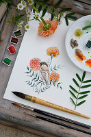 Painting utensils and watercolour painting of sparrow with marigold flowers on wooden table