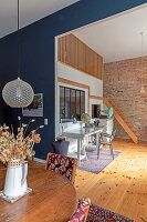Open-plan loft-style living area with desk, vintage décor and brick wall