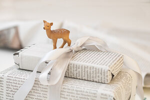 Gifts in newspaper with decorative deer and white ribbon