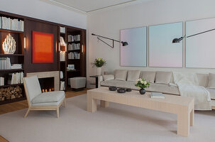 Minimalistisches Wohnzimmer mit cremefarbener Samtcouch und eingebautem Bücherregal