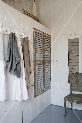 Towels Hanging On Row Of Coat Hooks Next To Ed Wardrobe With Towels Hanging On Row Of Coat Hooks Next To Ed Wardrobe With Rustic Louvre Doors In White Wood Clad Parion