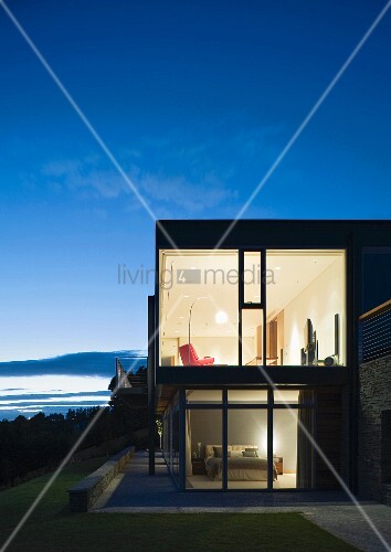 Haus Mit Glasfront In Abendbeleuchtung Bild Kaufen 11024243