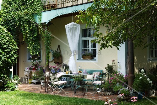 Seating area on terrace with delicate, shabby chic garden furniture ... Seating area on terrace with delicate, shabby chic garden furniture ...